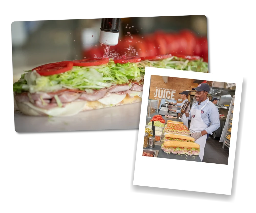 Close-up of oil being drizzled over a freshly made sub piled with lettuce and tomato, alongside a Jersey Mike’s team member preparing sandwiches in-store.